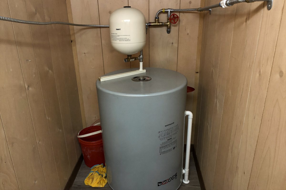 Expansion tank installed on the cold water line beside a water heater in a Charlotte garage